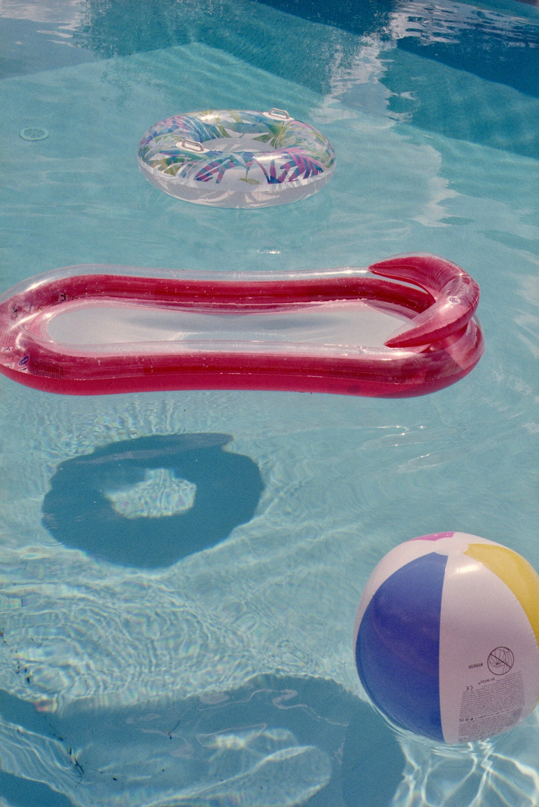 Inflatable pool toys float in clear blue water