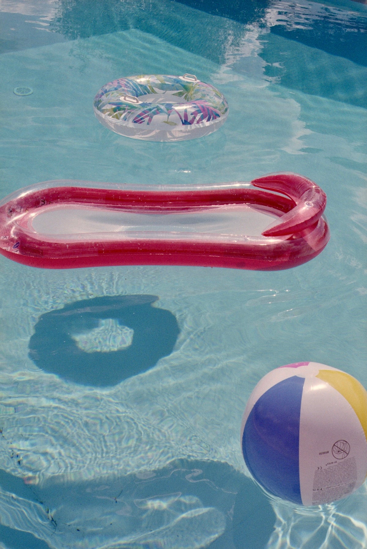 Inflatable pool toys float in clear blue water